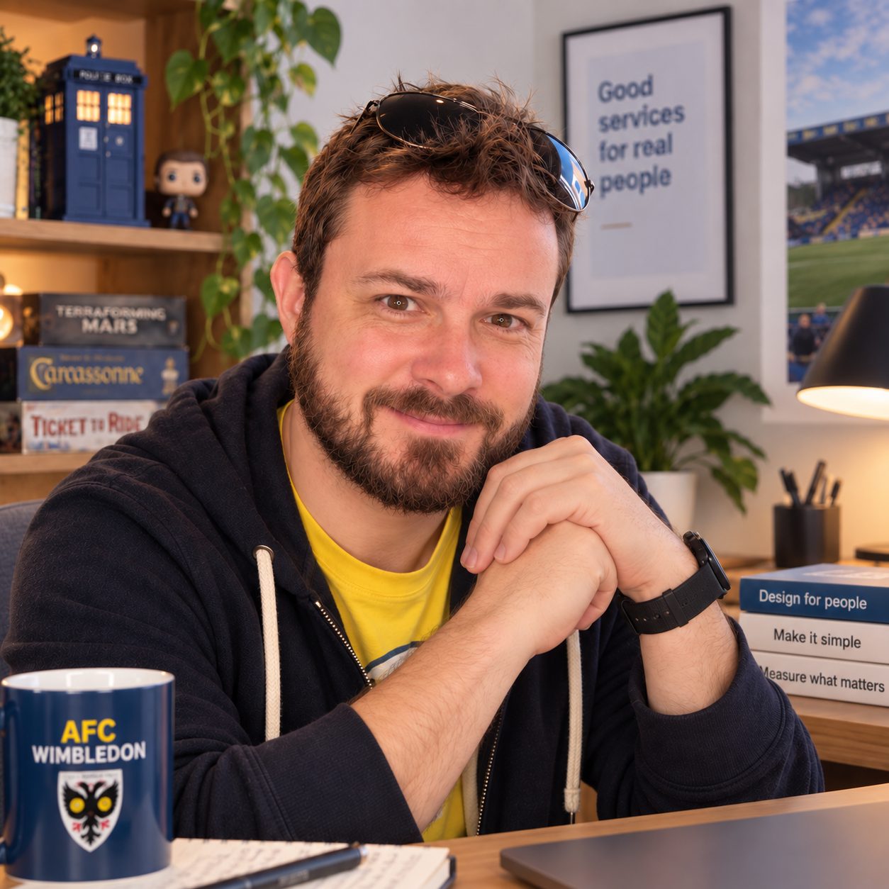 Dominic Francis at his desk with an AFC Wimbledon mug, Doctor Who memorabilia and board games